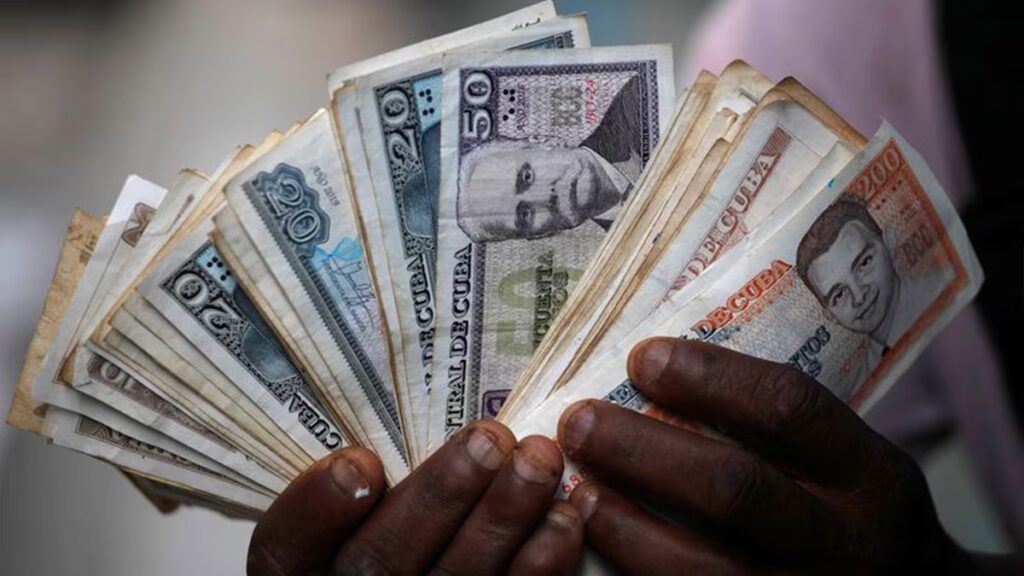 El peso cubano alcanza mínimo histórico 6 En la foto, unas manos sujetan muchos pesos cubanos