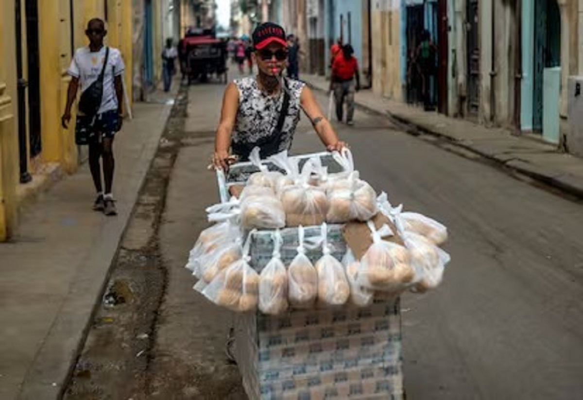 En la foto, un hombre vende pan en la calle