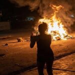 En la foto, una mujer firma un fuego en una calle de Cuba
