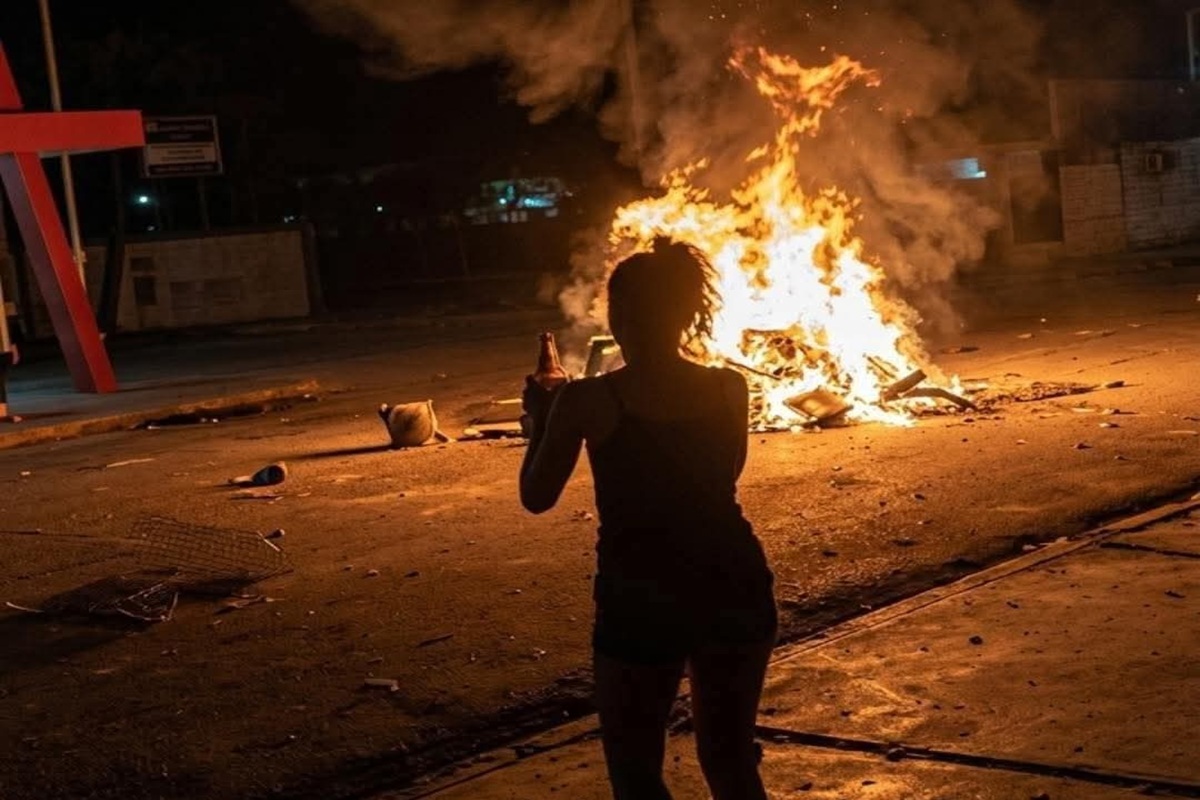 En la foto, una mujer firma un fuego en una calle de Cuba