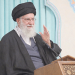 Fotografía con tonos suaves y pastel de Ali Jameneí, líder supremo de Irán, hablando desde un podio de madera.