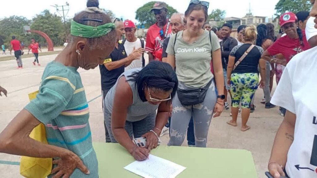 En la foto, cubanos firman el libro de apoyo al gobierno
