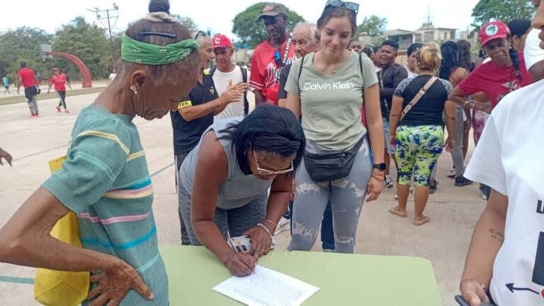 En la foto, cubanos firman el libro de apoyo al gobierno