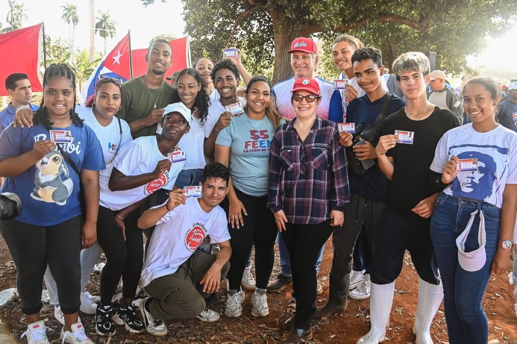 En la foto, el presidente de Cuba y la no primera dama posan con jóvenes que fingen alegría al recibir el carné de la juventud comunista