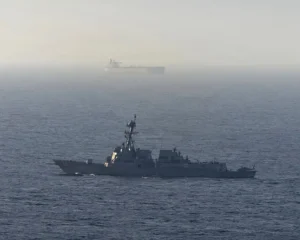 En la foto, un destructor de misiles guiados estadounidense cerca de un buque de carga en el mar Arábigo