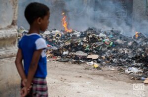 En la foto, un niño observa la quema de basura en La Habana