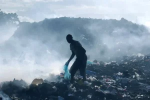En la foto, Un hombre busca en la basura en Puerto Príncipe
