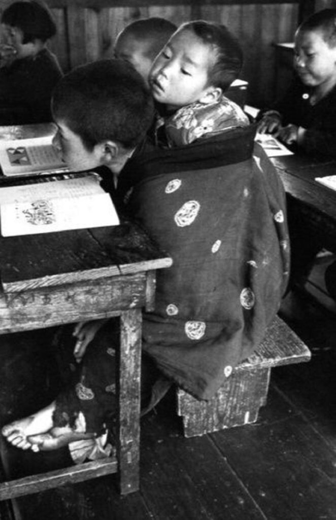 En la foto, el niño que lleva a su hermanito en la espalda en clases