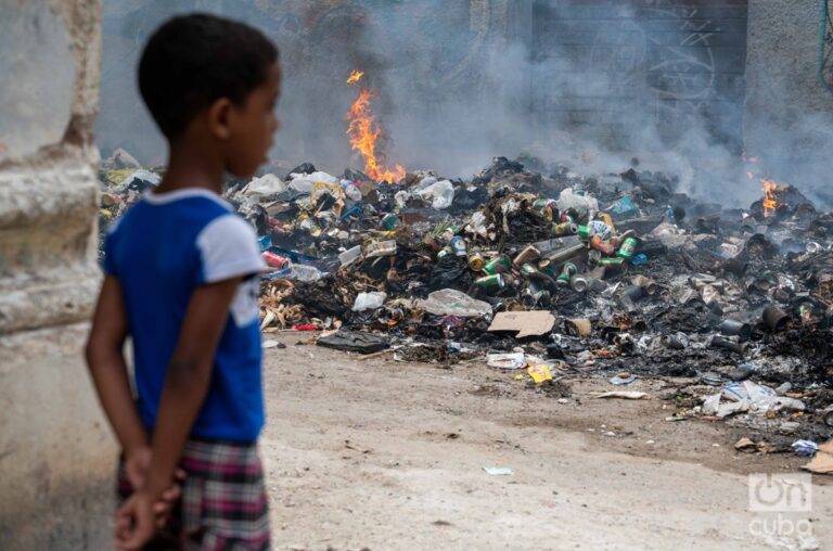 En la foto, un niño observa la quema de basura en La Habana