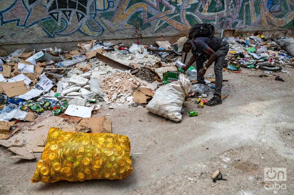En la foto, un hombre busca entre la basura en La Habana