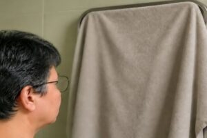 En la foto, una mujer ante un espejo tapado