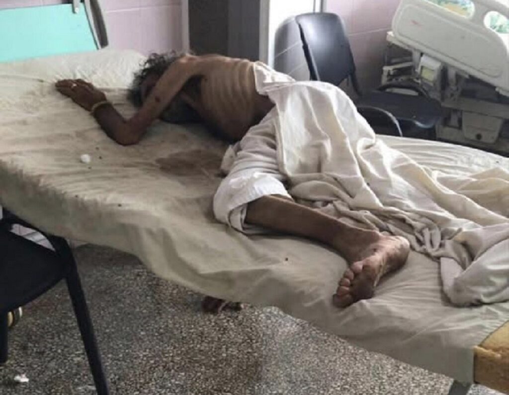 En la foto, un hombre yace sobre una cama de un hospital
