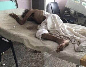 En la foto, un hombre yace sobre una cama de un hospital