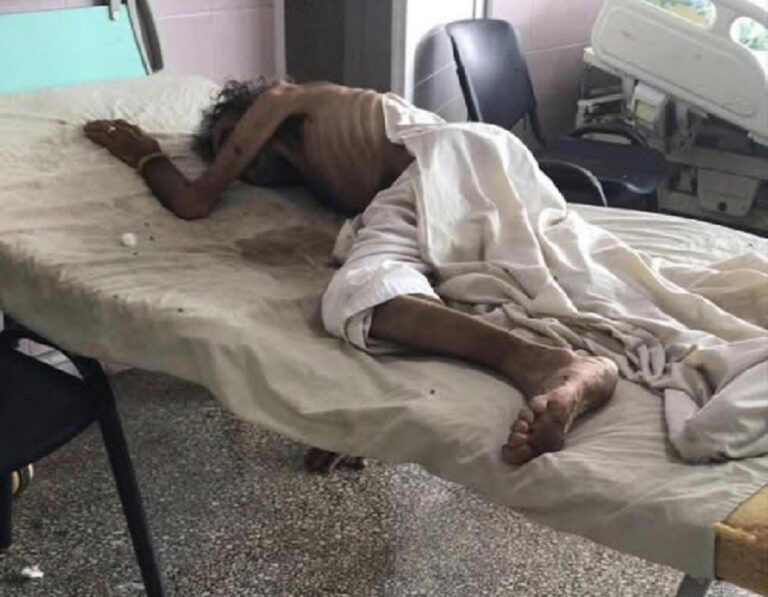 En la foto, un hombre yace sobre una cama de un hospital