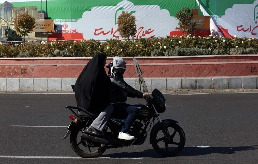 En la foto, Una pareja iraní conduce una motocicleta en una calle de Teherán