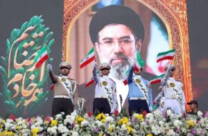 En la foto, Miembros del ejército iraní ondean banderas nacionales frente a un cartel del líder supremo iraní, el ayatolá Mojtaba Jamenei, durante una manifestación en Teherán