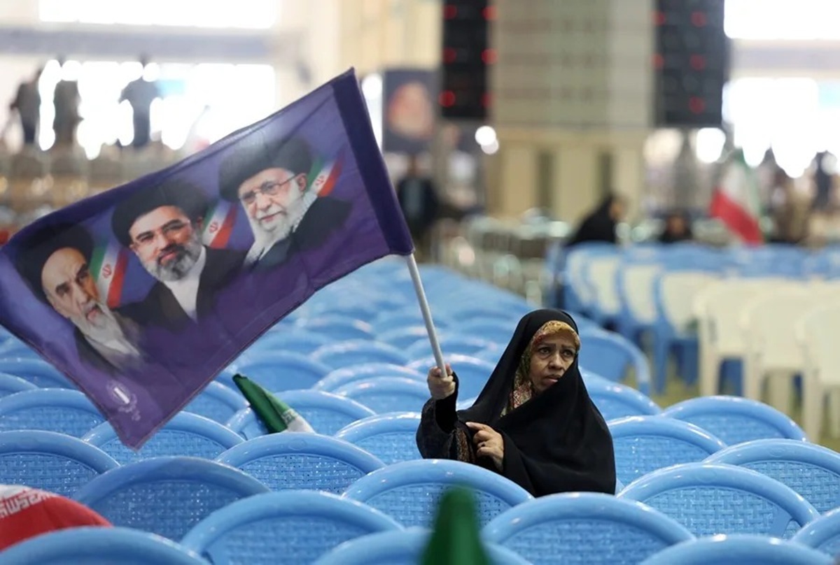 Irán reconoce avances en las negociaciones con EE.UU. pero dice que el acuerdo no es inminente 1 En la foto, Una mujer iraní sostiene una bandera con los retratos de los difuntos líderes supremos y el actual, en una ceremonia en memoria de los caídos en la guerra con EE.UU. e Israel, celebrada el domingo en la mezquita de Mosallah en Teherán.