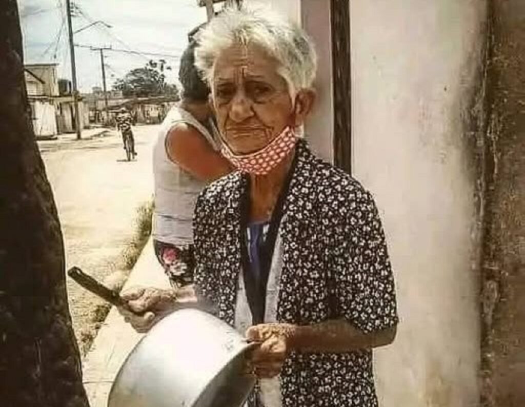 En la foto, una anciana cubana toca una cazuela