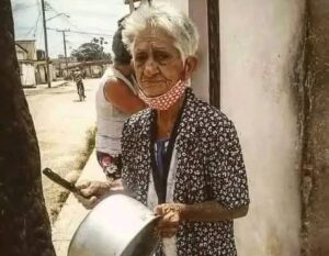 En la foto, una anciana cubana toca una cazuela