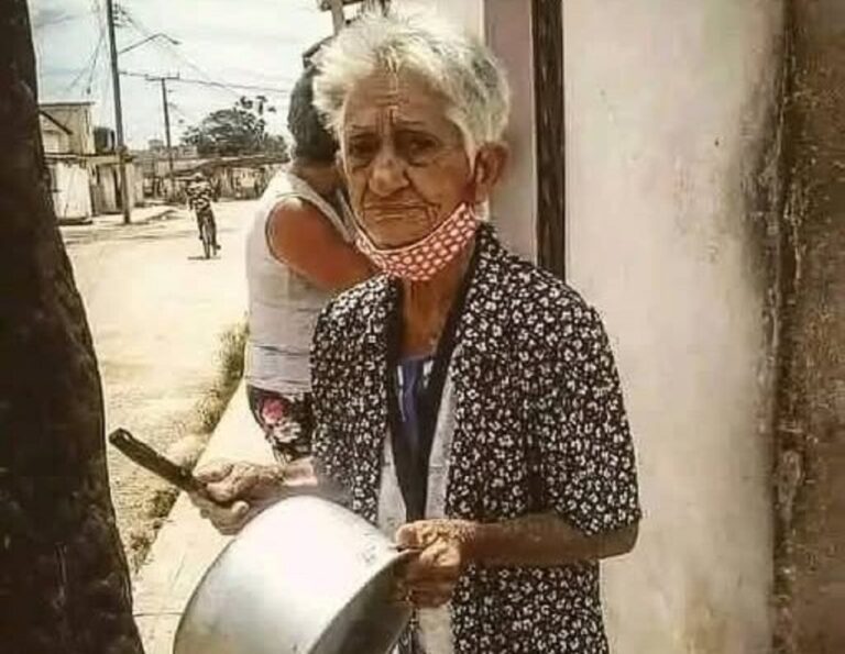 En la foto, una anciana cubana toca una cazuela