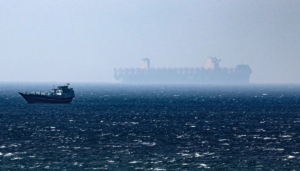 En la foto, un barco navega por el estrecho de Ormuz
