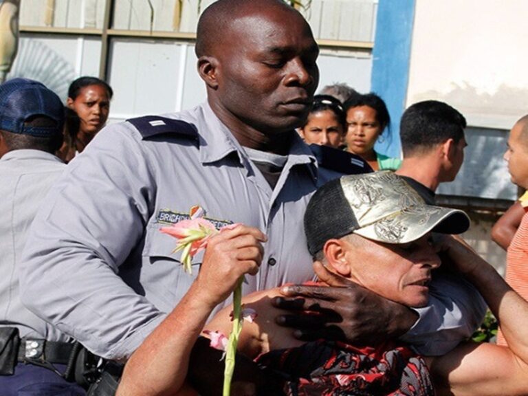 En la foto, un policía negro reprime a un manifestante en Cuba