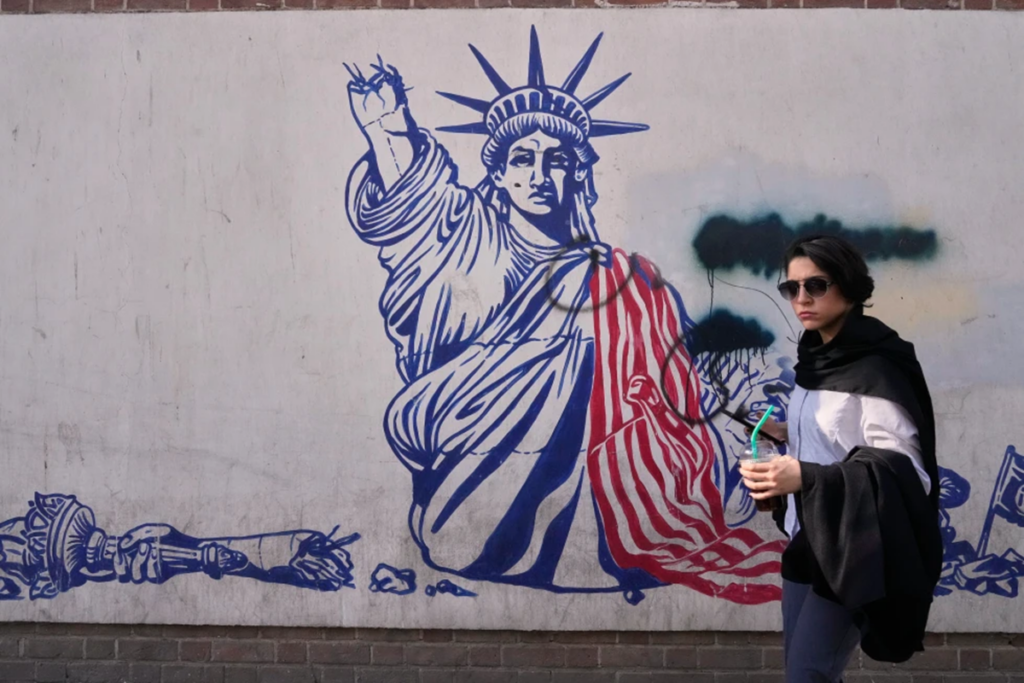 En la foto, Una mujer pasa junto a un mural antiestadounidense en la pared de la antigua embajada de Estados Unidos, ahora convertida en museo, en Teherán