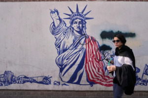 En la foto, Una mujer pasa junto a un mural antiestadounidense en la pared de la antigua embajada de Estados Unidos, ahora convertida en museo, en Teherán