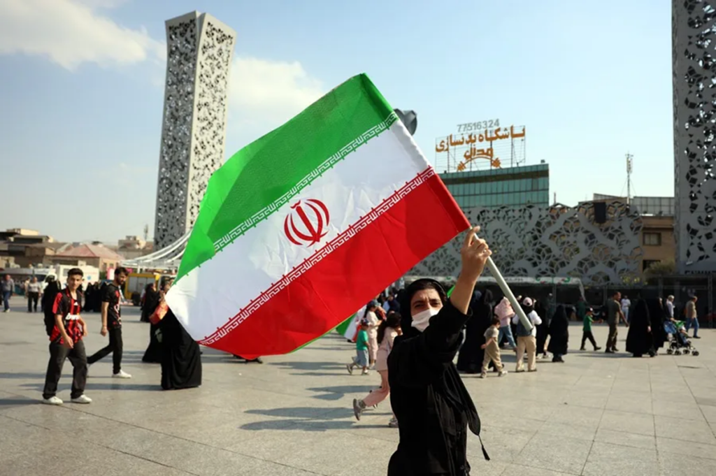 En la foto, una mujer sosteniendo la bandera de Irán en Teherán