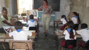 En la foto, una maestra da clases en un aula en Cuba