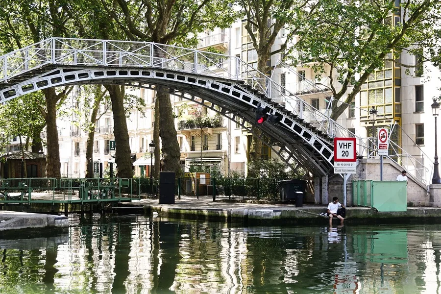 En la foto, Un hombre se refresca en el canal de Saint-Martin de París