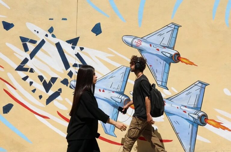En la foto, Ciudadanos iraníes caminan junto a un mural antiestadounidense en Teherán, este 3 de junio.