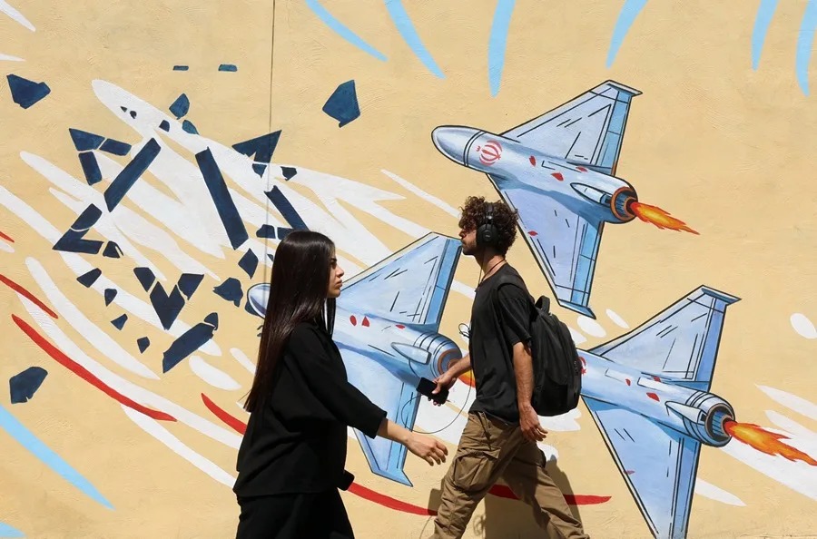 En la foto, Ciudadanos iraníes caminan junto a un mural antiestadounidense en Teherán, este 3 de junio.