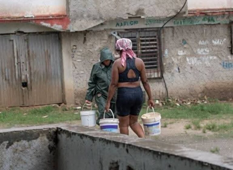 En la foto, mujeres acarrean agua de lluvia bajo un aguacero