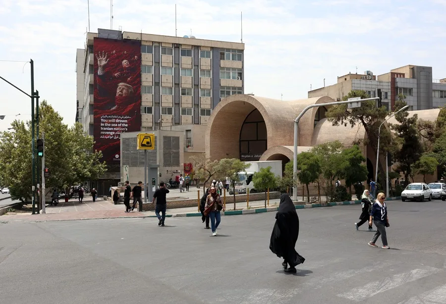 La ONU alerta de la posible ejecución de 10 jóvenes en relación con protestas en Irán 2 En la foto, iraníes caminando junto a una valla publicitaria contra EE.UU. e Israel, en una calle de Teherán