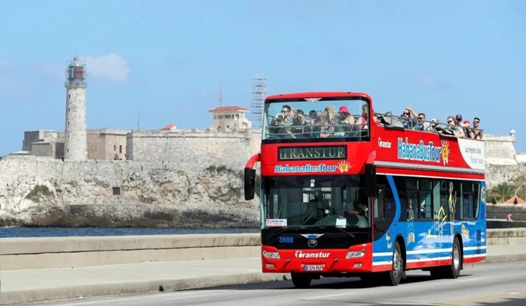 En la foto, imagen de archivo de turistas que pasean en un bus turístico por el Malecón de La Habana