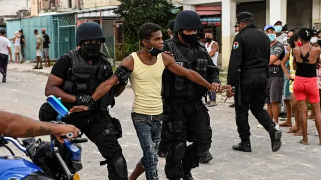 En la foto, personas impasibles ante la detención de un hombre que protestaba
