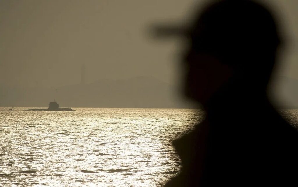 En la foto, Un ciudadano observa un submarino de la Armada china