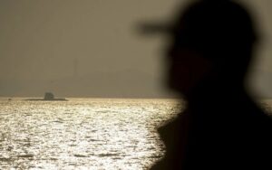 En la foto, Un ciudadano observa un submarino de la Armada china