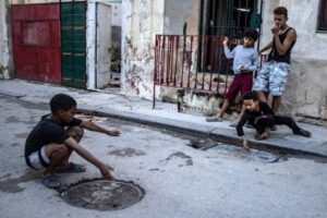 En la foto, niños cubanos juegan en la calle