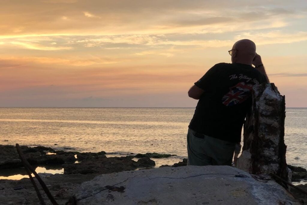 Los cómplices del hambre 2 En la foto, un hombre mira al mar al atardecer