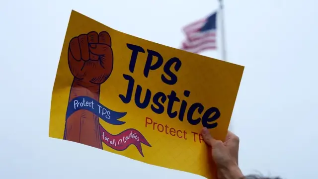 En la foto, una persona sosteniendo un cartel durante una manifestación a favor del beneficio del TPS, en Washington