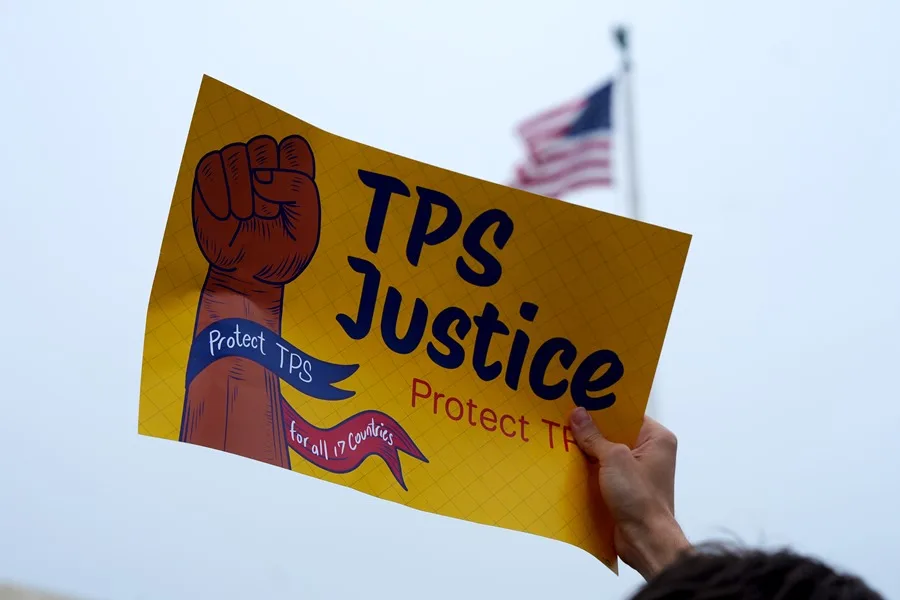 En la foto, una persona sosteniendo un cartel durante una manifestación a favor del beneficio del TPS, en Washington