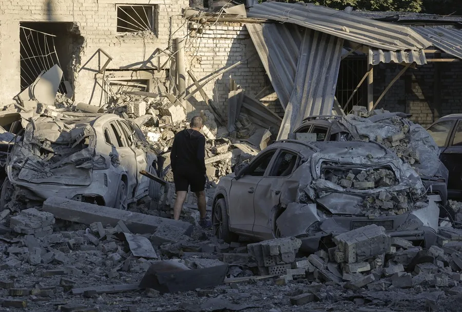 En la foto, Residentes locales este jueves en el lugar de un ataque ruso con misiles en una zona residencial en Kiev