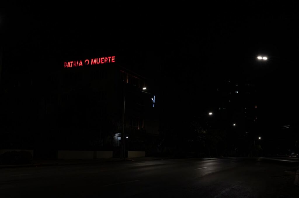 En la foto, un letrero de "Patria o Muerte", lo único encendido en medio de un apagón
