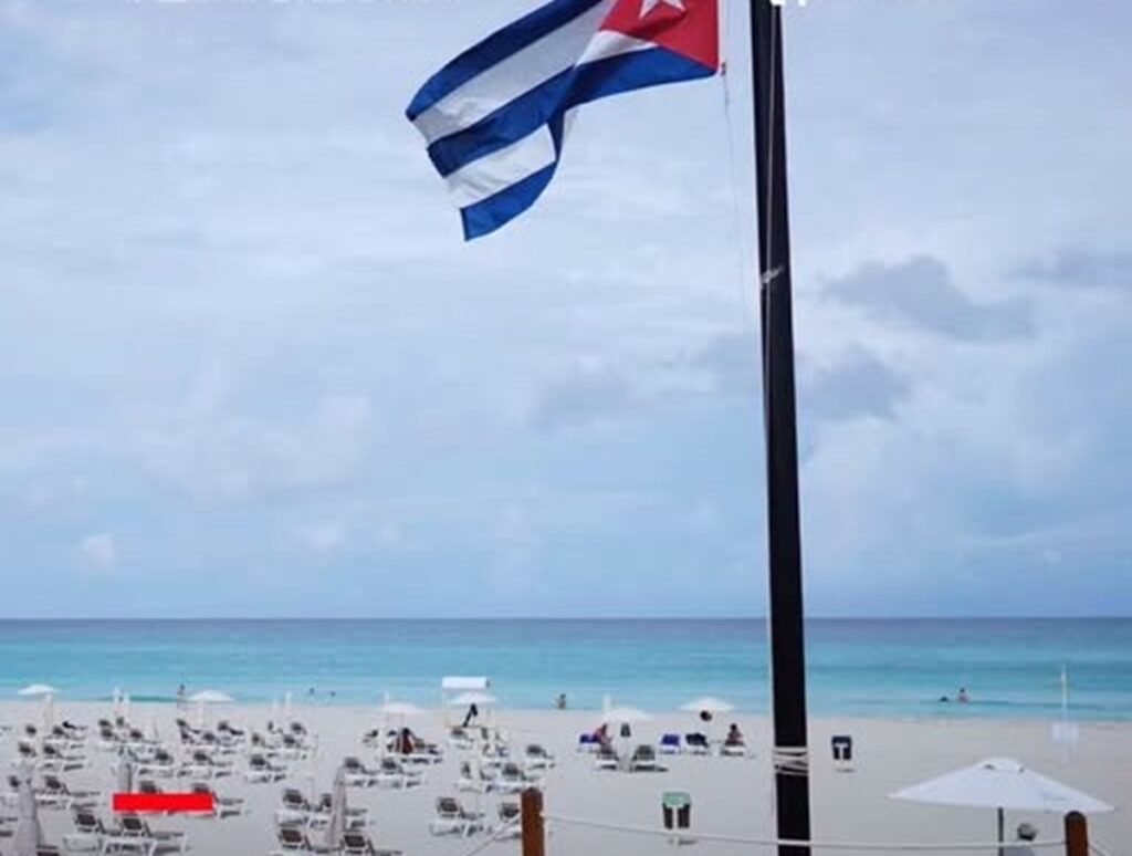 En la foto, una bandera cubana ondea en una playa