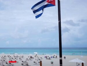 En la foto, una bandera cubana ondea en una playa