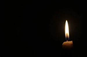 En la foto, una vela encendida en la oscuridad