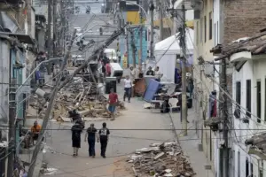 Personas caminan frente a edificaciones afectadas por el terremoto de magnitud 7,4, en Pereira