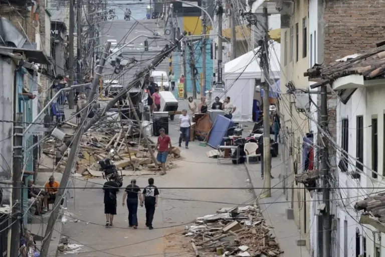 Personas caminan frente a edificaciones afectadas por el terremoto de magnitud 7,4, en Pereira